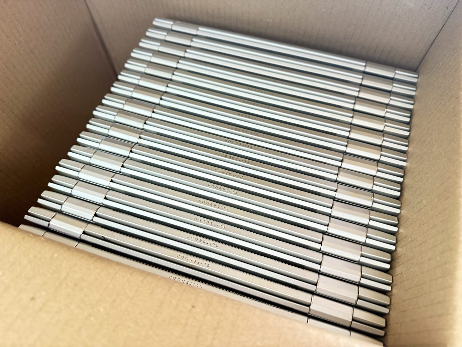 A box of retired business laptops collected for refurbishment